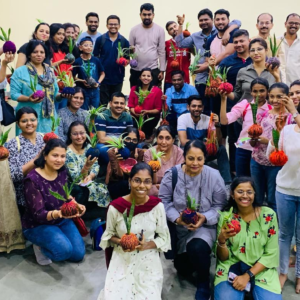 People holding up their Kokedama Workshop plants at Maharashtra Nature Park